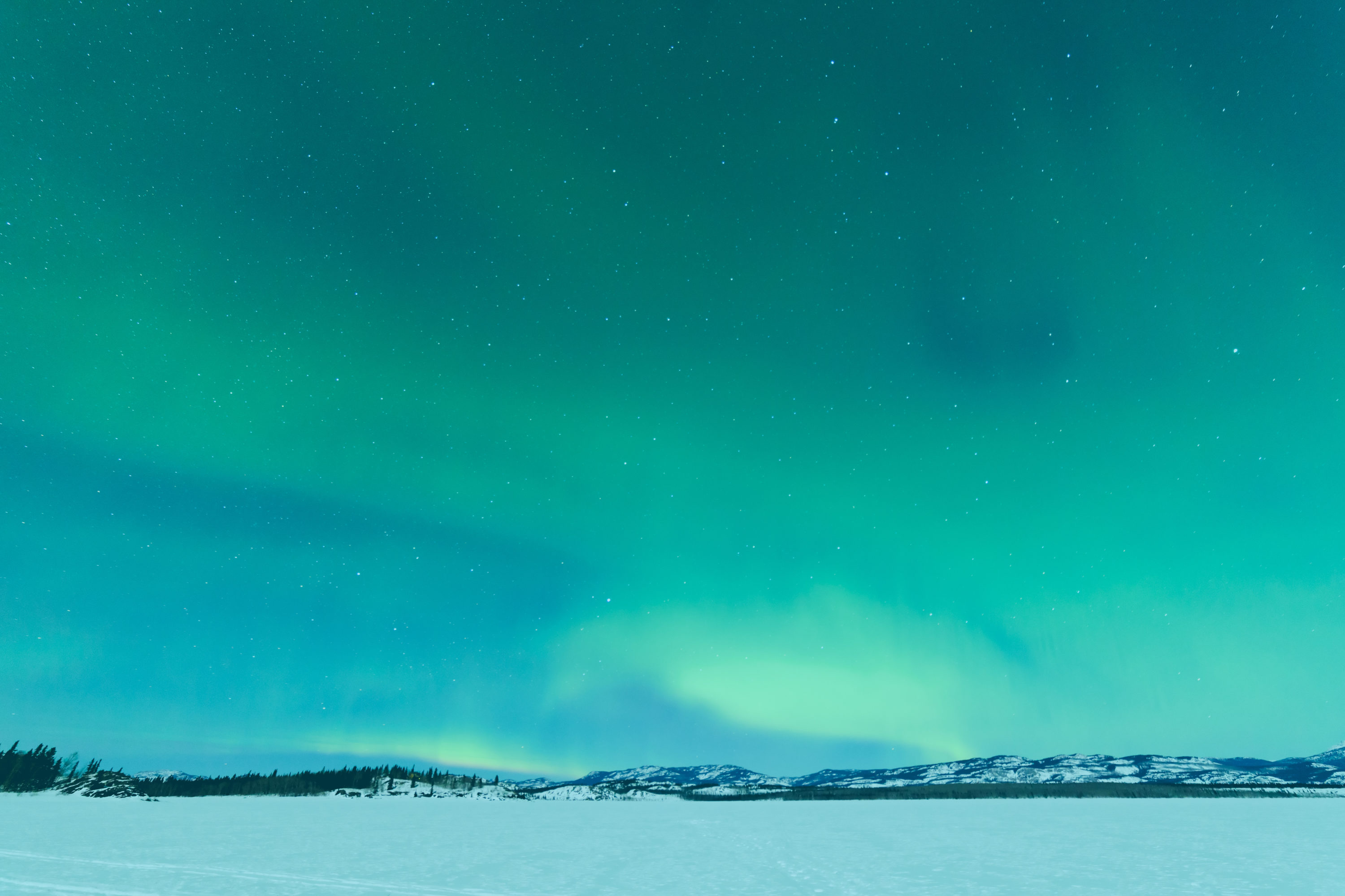 Et grønt lys på himmelen over et snødekt felt